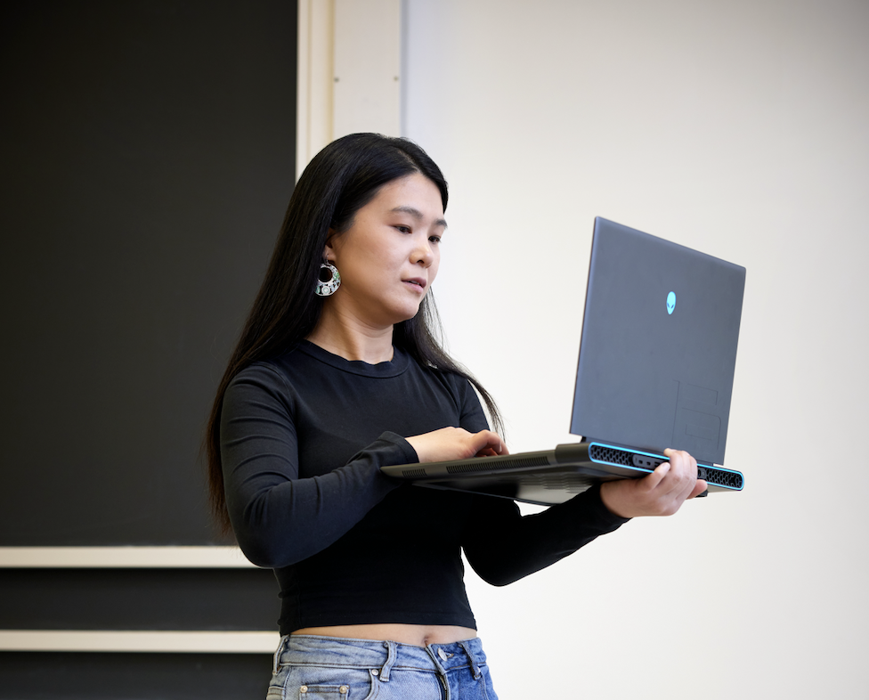 a woman works on a laptop while standing