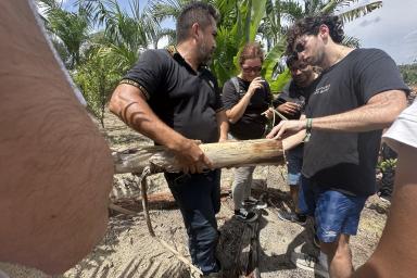 MIT student Max Siegel (right) examines local vegetation for potential uses.